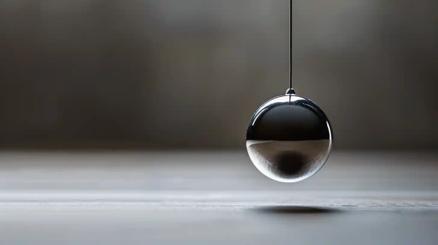 A glass pendulum suspended in equilibrium, symbolizing inner rhythm and the moment just before movement.